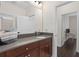 Bathroom vanity with gray countertop, wood cabinets, large mirror and access to shower at 13831 Briand Ave, Orlando, FL 32827