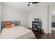 Bedroom with a ceiling fan, neutral decor, a gray padded headboard and an open doorway at 13831 Briand Ave, Orlando, FL 32827