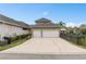This view showcases a two car garage and a large concrete driveway at 13831 Briand Ave, Orlando, FL 32827
