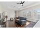 Bright main bedroom features tray ceiling, dark wood floors, sitting area with leather couch, and plantation shutters at 13831 Briand Ave, Orlando, FL 32827