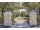 A stone pillar entryway leads to a verdant park with mature trees and a walking path at 13831 Briand Ave, Orlando, FL 32827