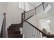 Elegant staircase with dark wood railings, white risers, and natural light at 13831 Briand Ave, Orlando, FL 32827