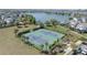 Aerial view of two well-maintained tennis courts in a landscaped community near a lake and residential neighborhood at 13831 Briand Ave, Orlando, FL 32827