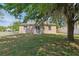 The home features a well-manicured backyard with green grass, mature trees, and an outdoor patio at 1502 Fern Bay Ct, Orlando, FL 32824