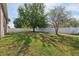 Large, well-maintained backyard with green grass, mature trees offering shade, and a white privacy fence at 1502 Fern Bay Ct, Orlando, FL 32824