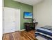 A bedroom featuring wood floors, green accent wall, desk and large window at 1502 Fern Bay Ct, Orlando, FL 32824