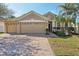 Charming single-Gathering home featuring a three-car garage, brick driveway, and lush landscaping at 1502 Fern Bay Ct, Orlando, FL 32824