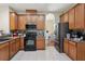This traditional kitchen features wood cabinets, black appliances, and a mosaic tile backsplash at 1502 Fern Bay Ct, Orlando, FL 32824