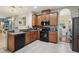 Traditional kitchen features wooden cabinets, black appliances, and a view of the adjacent dining room at 1502 Fern Bay Ct, Orlando, FL 32824