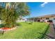 Wide backyard view with mature palm trees, playset, patio and grill, providing a Gathering-friendly outdoor space at 1518 Mississippi Ave, St Cloud, FL 34769