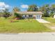 Charming single-story home with a well-manicured lawn, mature trees, and a welcoming facade at 1518 Mississippi Ave, St Cloud, FL 34769