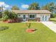 Charming single-story home boasts a lush green lawn, complemented by palm trees and tasteful landscaping at 1518 Mississippi Ave, St Cloud, FL 34769