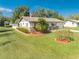 Inviting single-story home with a vibrant lawn, manicured landscaping, and an American flag, creating a welcoming atmosphere at 1518 Mississippi Ave, St Cloud, FL 34769