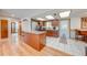 Open kitchen design boasts wood cabinets, island, granite countertops, stainless steel appliances, and bright lighting at 1518 Mississippi Ave, St Cloud, FL 34769