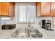 Close-up view of the kitchen sink featuring granite countertops and tiled backsplash at 1518 Mississippi Ave, St Cloud, FL 34769