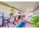 Covered patio features tile flooring, comfortable seating, and a wall-mounted TV, perfect for outdoor entertaining at 1518 Mississippi Ave, St Cloud, FL 34769