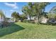 Spacious backyard with green grass, mature trees, and additional storage sheds at 1622 Marlin St, St Cloud, FL 34771