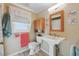 Clean bathroom with a pedestal sink, wooden accents, and bright natural light at 1622 Marlin St, St Cloud, FL 34771