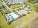 Aerial shot of a community pool with palm trees, lounge chairs, and green spaces in a residential area at 1723 Lake Sims Pkwy, Ocoee, FL 34761