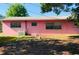 Rear exterior shot featuring a pink brick wall with multiple gated windows and AC unit at 205 Elinor S Ave, Dundee, FL 33838