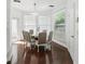 Bright dining room with hardwood floors and a glass table surrounded by six upholstered chairs at 205 Norfolk Pl, Celebration, FL 34747