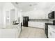 Bright kitchen featuring white cabinets, marble countertops, and black stainless steel appliances at 205 Norfolk Pl, Celebration, FL 34747
