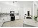Modern kitchen with white cabinets, granite countertops, black appliances, and a stylish backsplash at 205 Norfolk Pl, Celebration, FL 34747