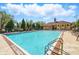 A clear view of the sparkling community pool with ample lounge chairs and an adjacent covered building at 205 Norfolk Pl, Celebration, FL 34747