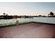 This backyard has a large paved patio and is lined by a white fence with a view of the lake beyond at 2224 Paria Ln, Kissimmee, FL 34758
