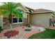 Front yard featuring a beautiful palm tree, decorative stone landscaping and a colorful walkway to the entrance at 2224 Paria Ln, Kissimmee, FL 34758