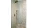 Modern shower featuring stone pebble flooring and accent wall, complemented by sleek fixtures at 2224 Paria Ln, Kissimmee, FL 34758