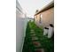 Side yard has a stepping stone path and a white fence with a view of the lake beyond, for secluded walks at 2224 Paria Ln, Kissimmee, FL 34758