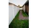 The side yard features a brick paver path, white vinyl fence, and green grass at 2224 Paria Ln, Kissimmee, FL 34758