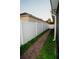 A brick paver walkway lines the side yard with a white vinyl fence at 2224 Paria Ln, Kissimmee, FL 34758