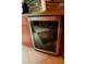 Close-up of the kitchen's sleek, stainless steel wine refrigerator built into wooden cabinetry at 2224 Paria Ln, Kissimmee, FL 34758