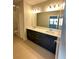 Bathroom featuring a double vanity, sleek cabinetry, a large mirror, and ample lighting at 231 Villa Domani Cir # 59, Davenport, FL 33896