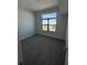 Bright bedroom with a large window offering exterior neighborhood views and neutral carpet at 231 Villa Domani Cir # 59, Davenport, FL 33896