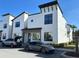 Modern townhome featuring a white exterior, dark trim, and a sleek sports car parked in front at 231 Villa Domani Cir # 59, Davenport, FL 33896