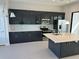 Contemporary kitchen with dark cabinetry, stainless steel appliances, and a functional center island at 231 Villa Domani Cir # 59, Davenport, FL 33896