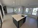 Open-concept kitchen with center island, stainless steel appliances, and modern pendant lighting at 231 Villa Domani Cir # 59, Davenport, FL 33896