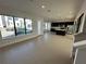 Open living room and kitchen with light ceramic floors and modern black cabinets at 231 Villa Domani Cir # 59, Davenport, FL 33896