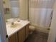 Bathroom with a single vanity, toilet, and shower/tub with white shower curtain and gray rug at 3007 Bransbury Ct, Kissimmee, FL 34747