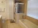 Bathroom featuring a glass-enclosed shower, tiled walls, soaking tub, and white shutter-style closet at 3007 Bransbury Ct, Kissimmee, FL 34747