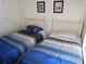 Cozy bedroom showcasing two twin beds with striped blue and gray bedding under framed pictures at 3007 Bransbury Ct, Kissimmee, FL 34747