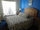 Bedroom with blue accent wall, queen bed with leaf-patterned comforter, and bright natural light at 3007 Bransbury Ct, Kissimmee, FL 34747