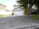 Front view of the home featuring a two car garage and drought tolerant landscaping at 3007 Bransbury Ct, Kissimmee, FL 34747