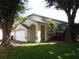 Eye-catching exterior showcasing a well-manicured lawn, arched entryway, and a two-car garage at 3007 Bransbury Ct, Kissimmee, FL 34747