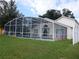 Back view of a beautiful single-story home, screened in-ground pool, patio, and a fenced yard at 3007 Bransbury Ct, Kissimmee, FL 34747