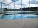 Sparkling screened-in pool area offering serene lake views, perfect for outdoor relaxation and enjoyment at 3007 Bransbury Ct, Kissimmee, FL 34747