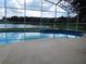 Inviting pool area with a screened-in enclosure overlooking a tranquil lake, great for leisure at 3007 Bransbury Ct, Kissimmee, FL 34747